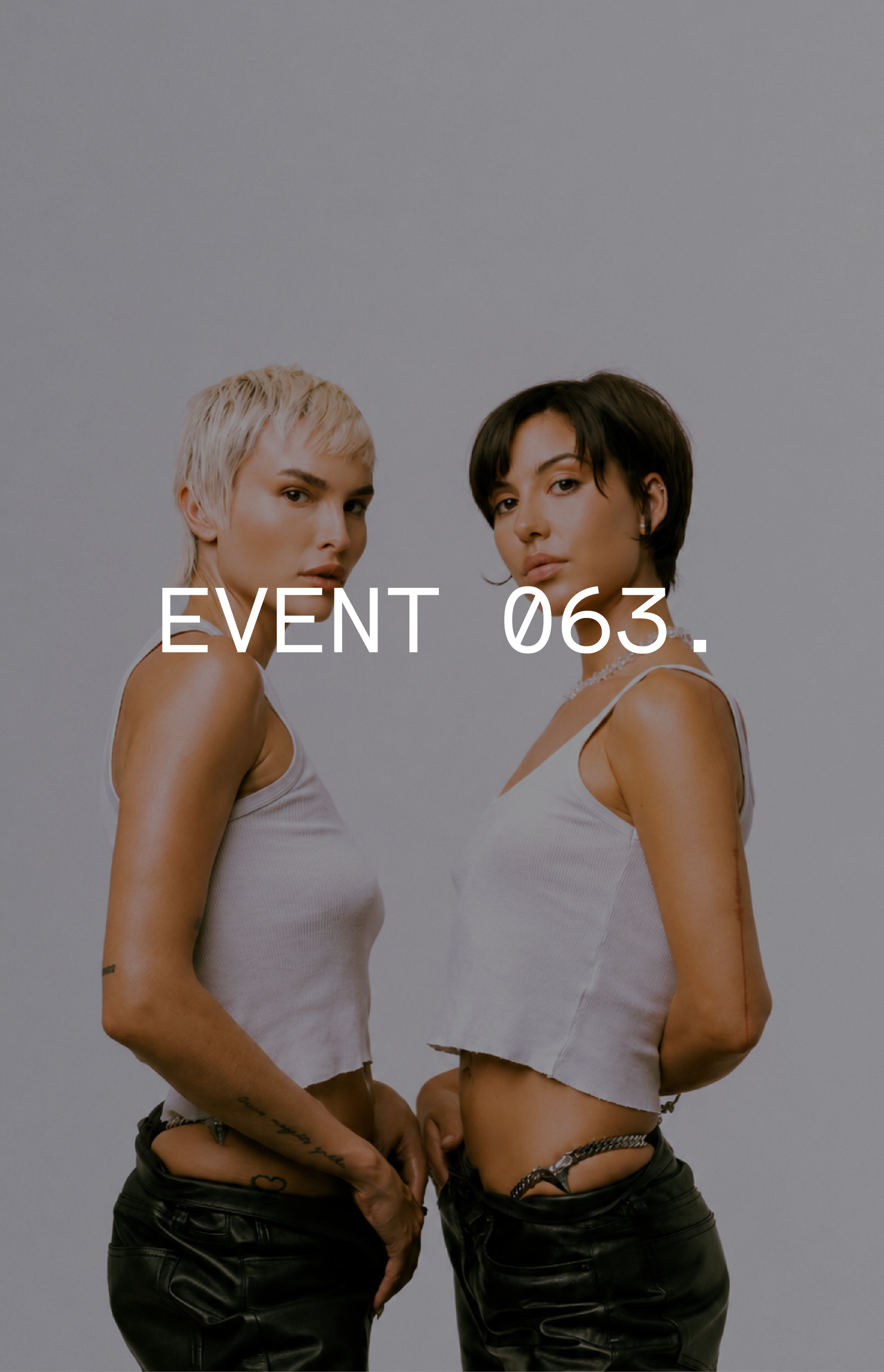 Two individuals in white tank tops and black pants stand side by side against a gray background with the text "EVENT 063." overlayed.