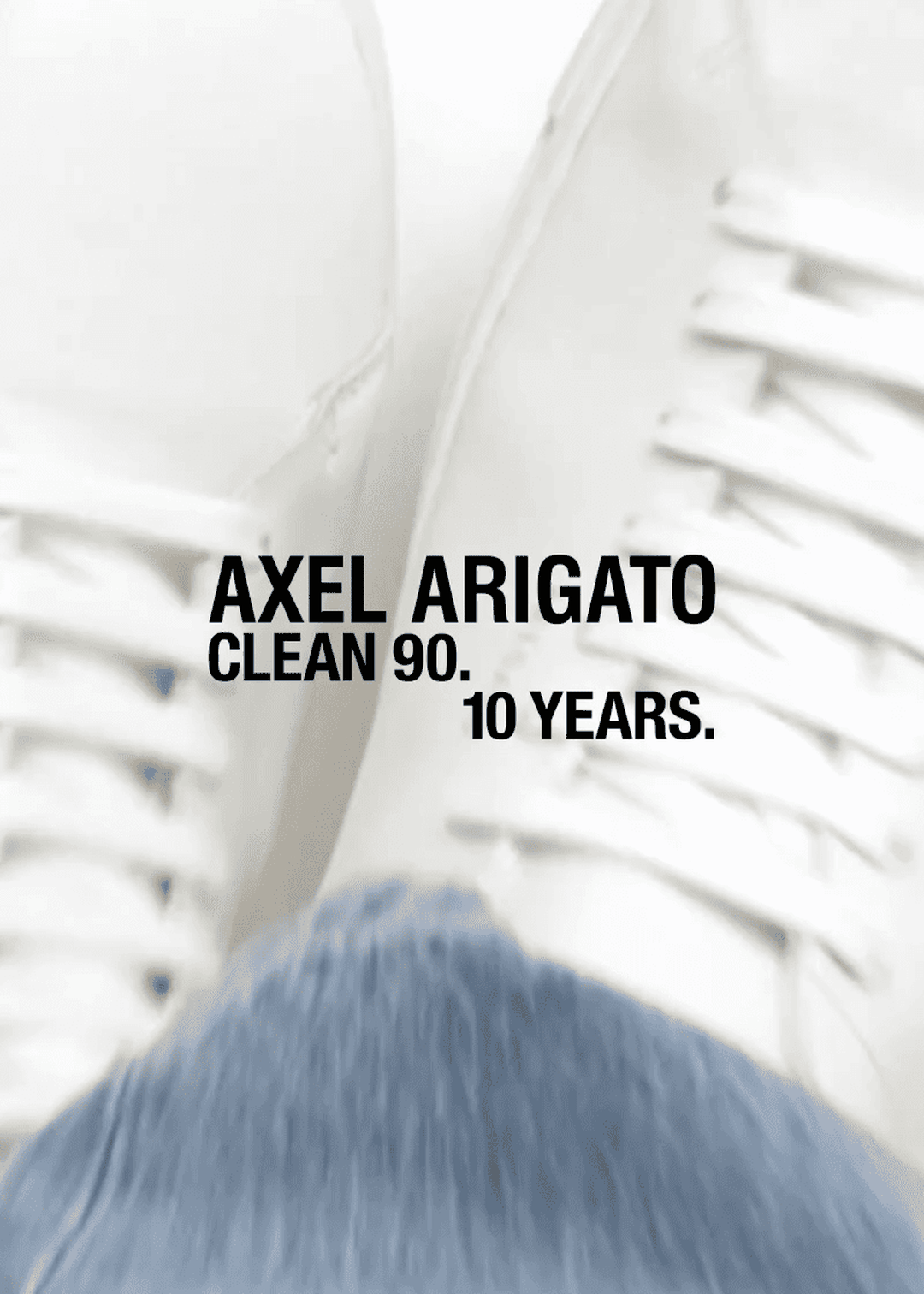 Close-up of white sneakers with "AXEL ARIGATO CLEAN 90. 10 YEARS." text overlay, showing the shoe design and anniversary celebration.