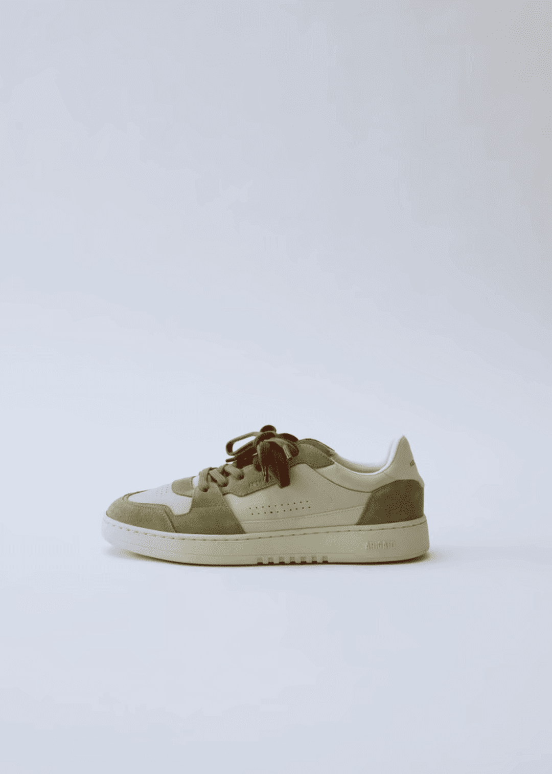 Beige and olive low-top sneaker with brown laces on a light gray background.