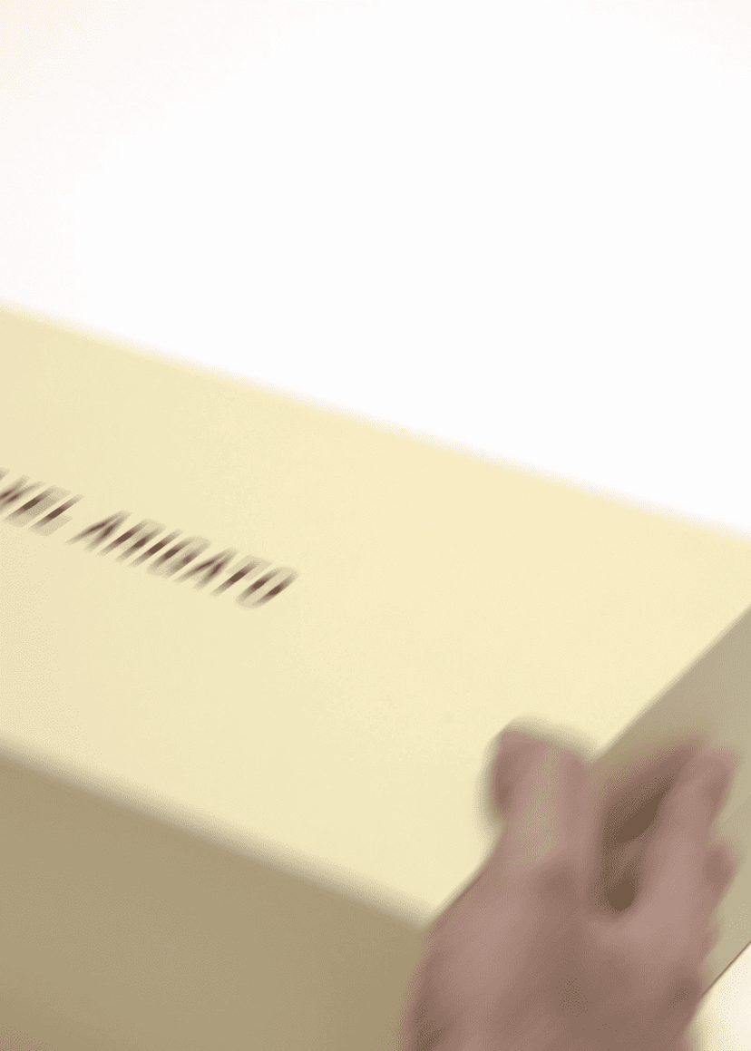 Hand opening a light yellow shoe box with "COMMON PROJECTS" text on the lid, against a plain white background.