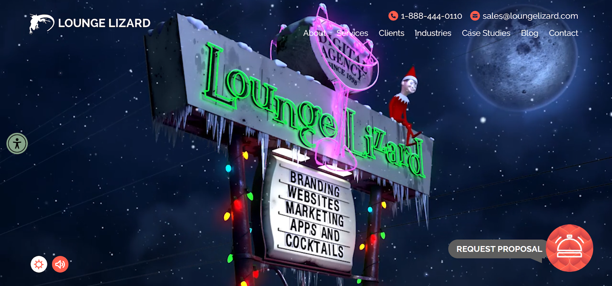 Neon sign for Lounge Lizard, featuring text on branding and apps, with holiday lights and an elf, set against a snowy night sky.