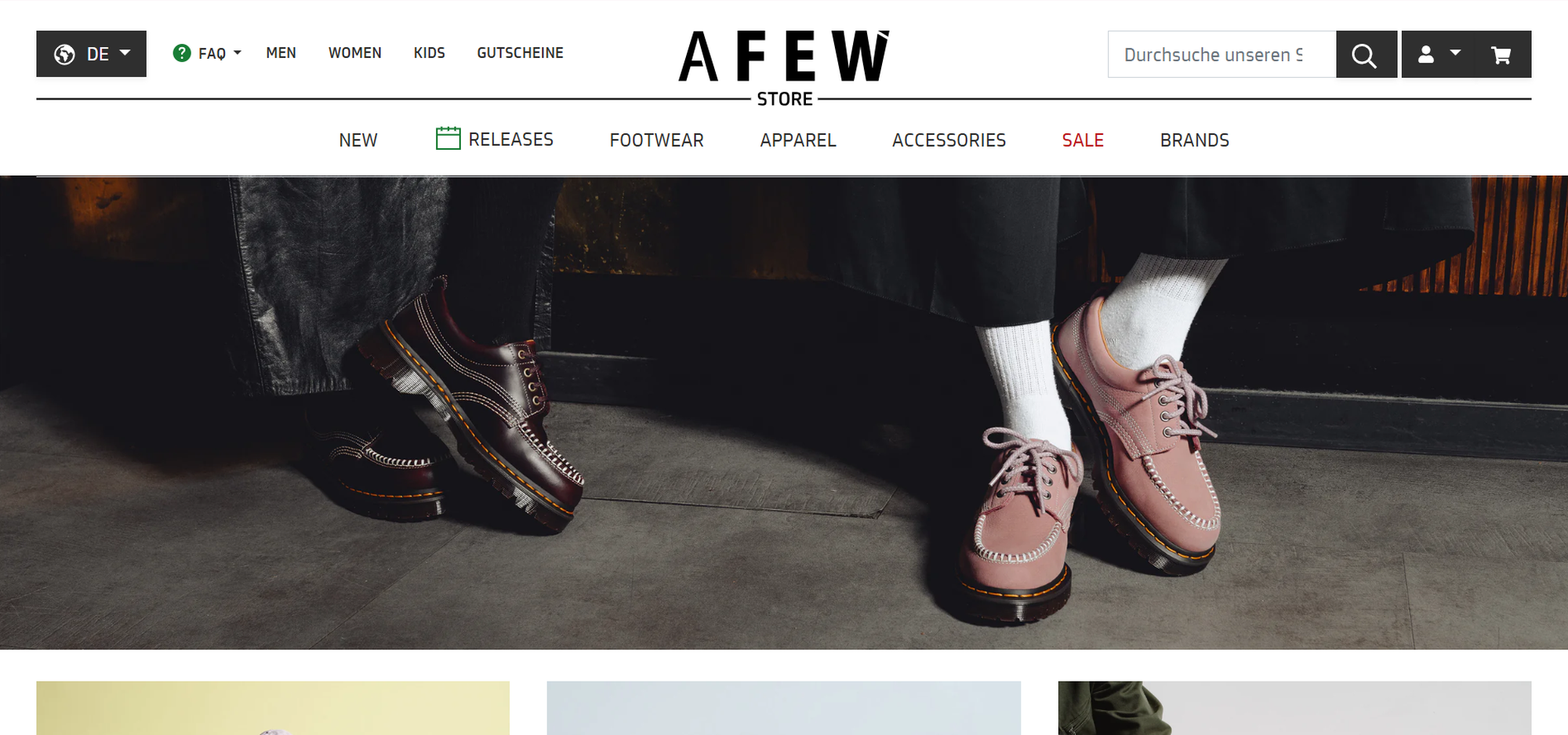 Two pairs of shoes in a store display: one black and one pink pair, both with white socks, against a stylish, cozy background.