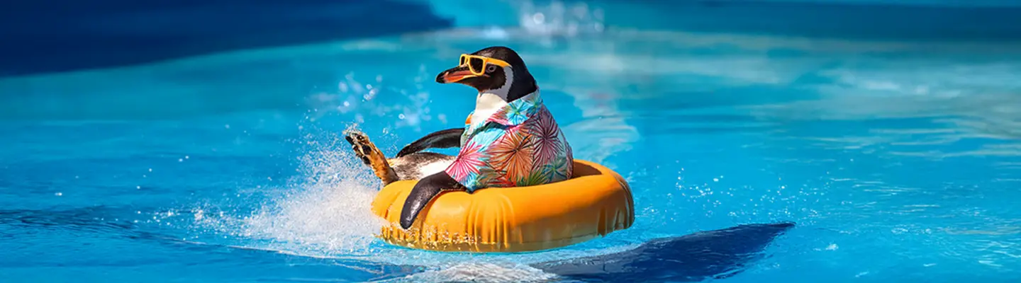 A penguin wearing colorful sunglasses and a shirt floats on an orange ring in a pool, creating splashes around.