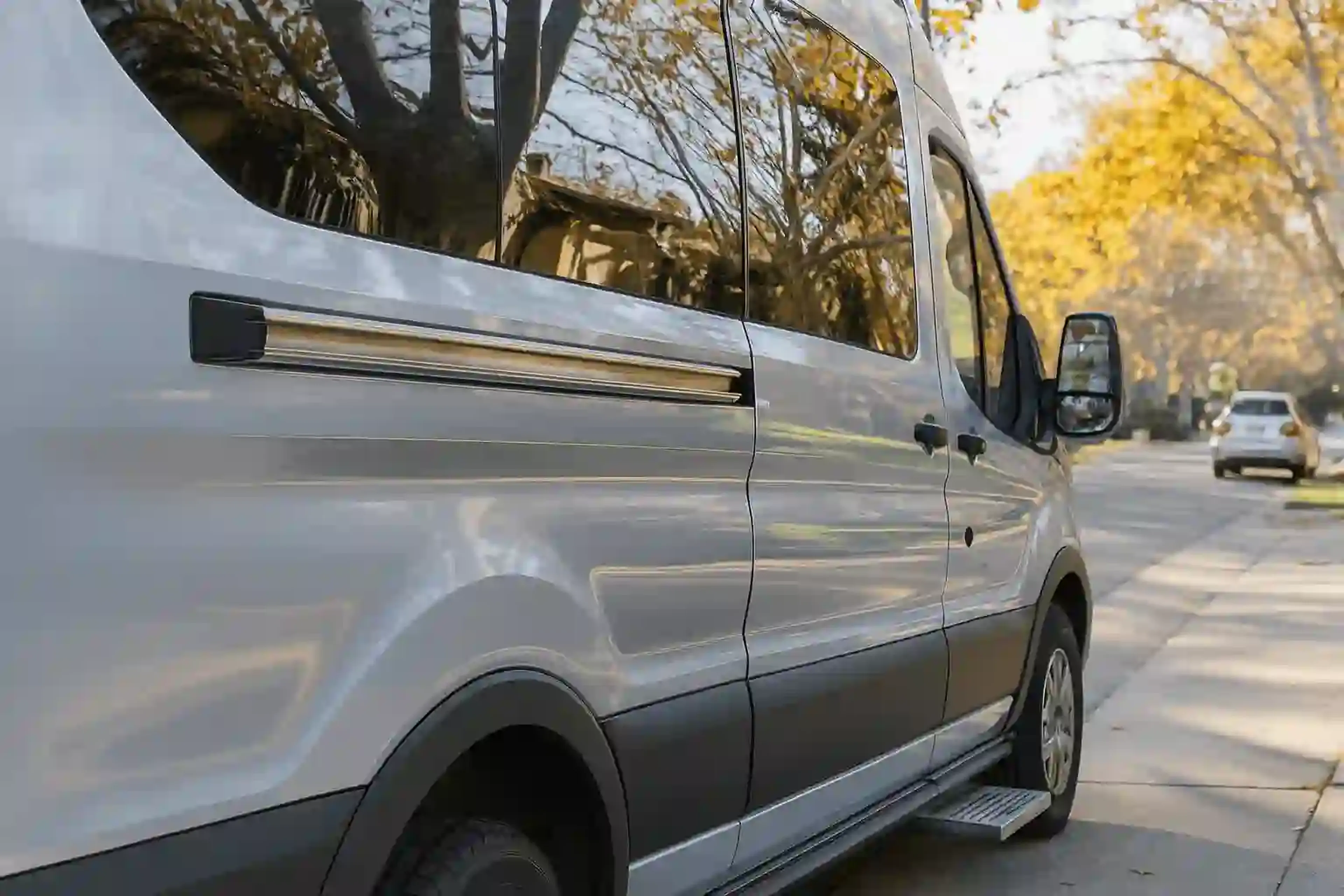A modern passenger shuttle van parked on a street