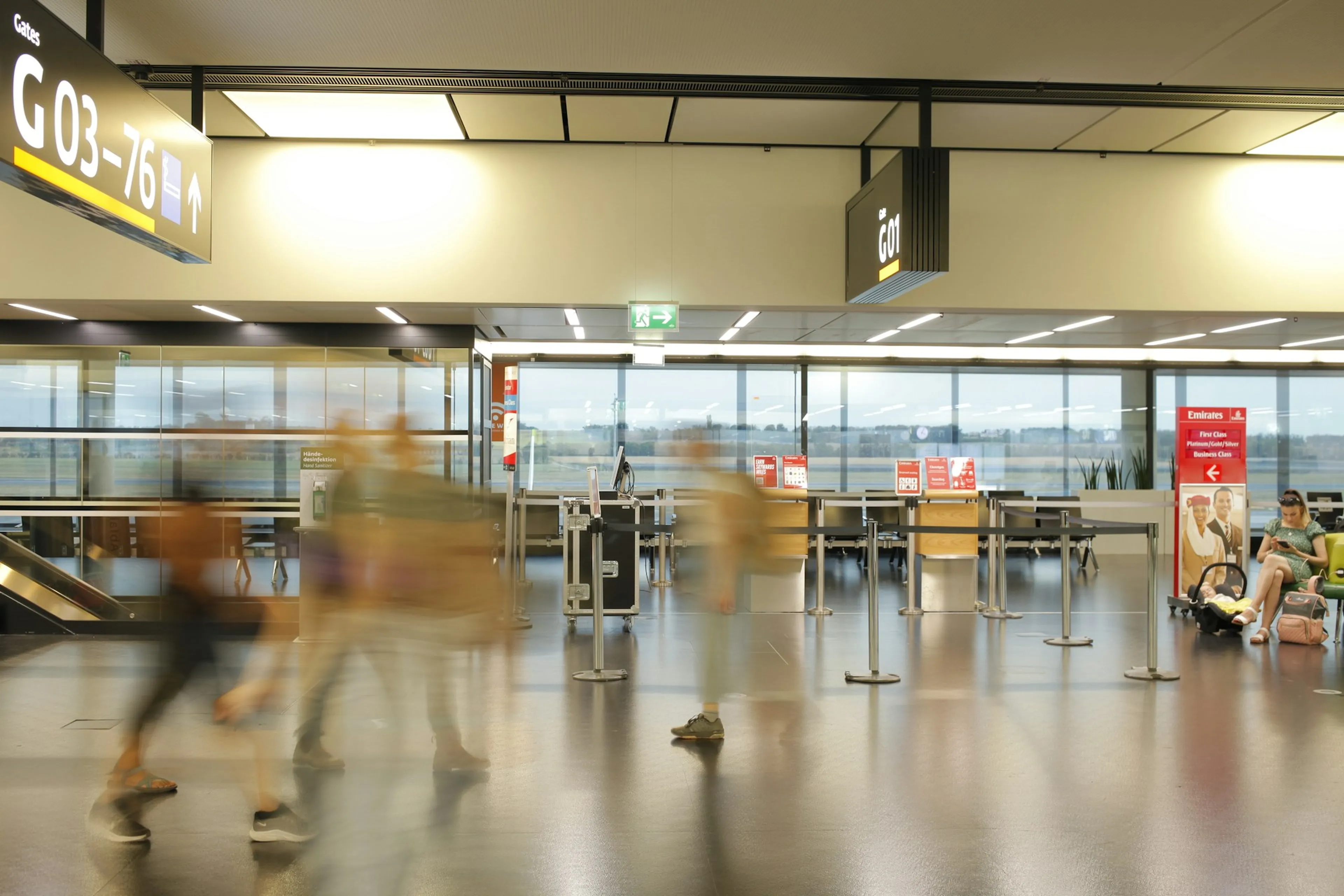 Airport gate queue with passengers walking past