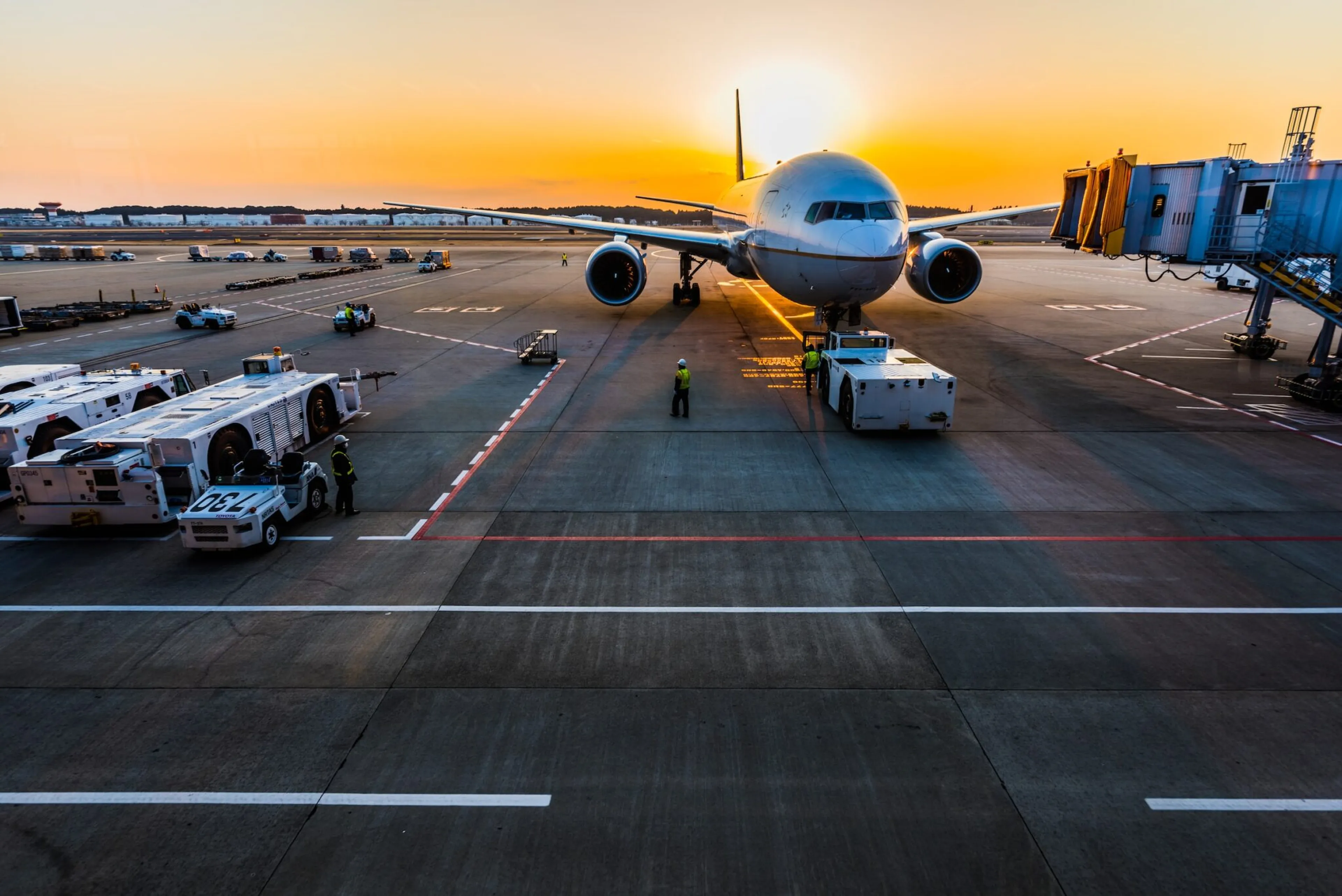 Airplane on airfield moving from jetway with ground handling staff