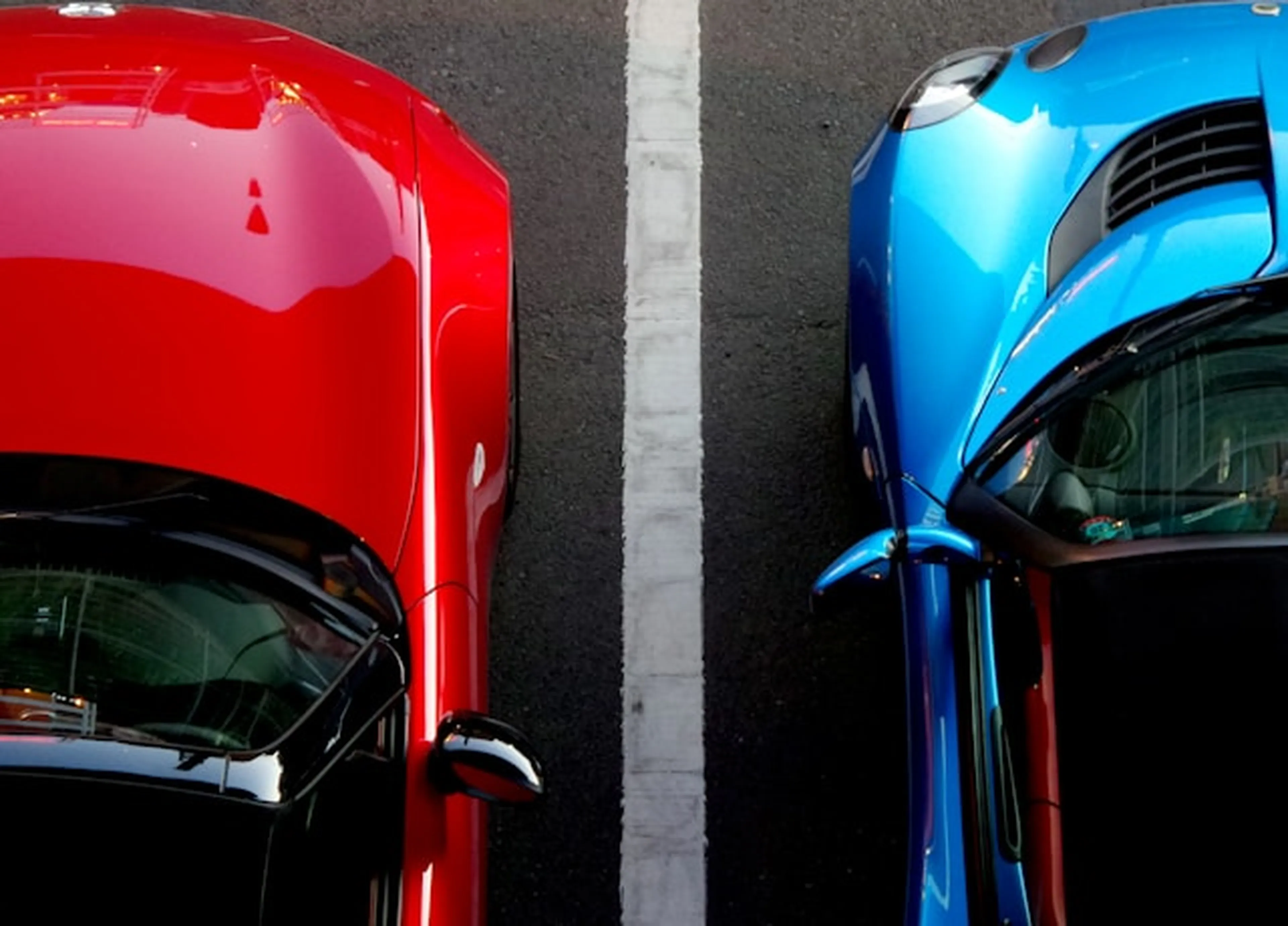 Red and blue cars parked in lot
