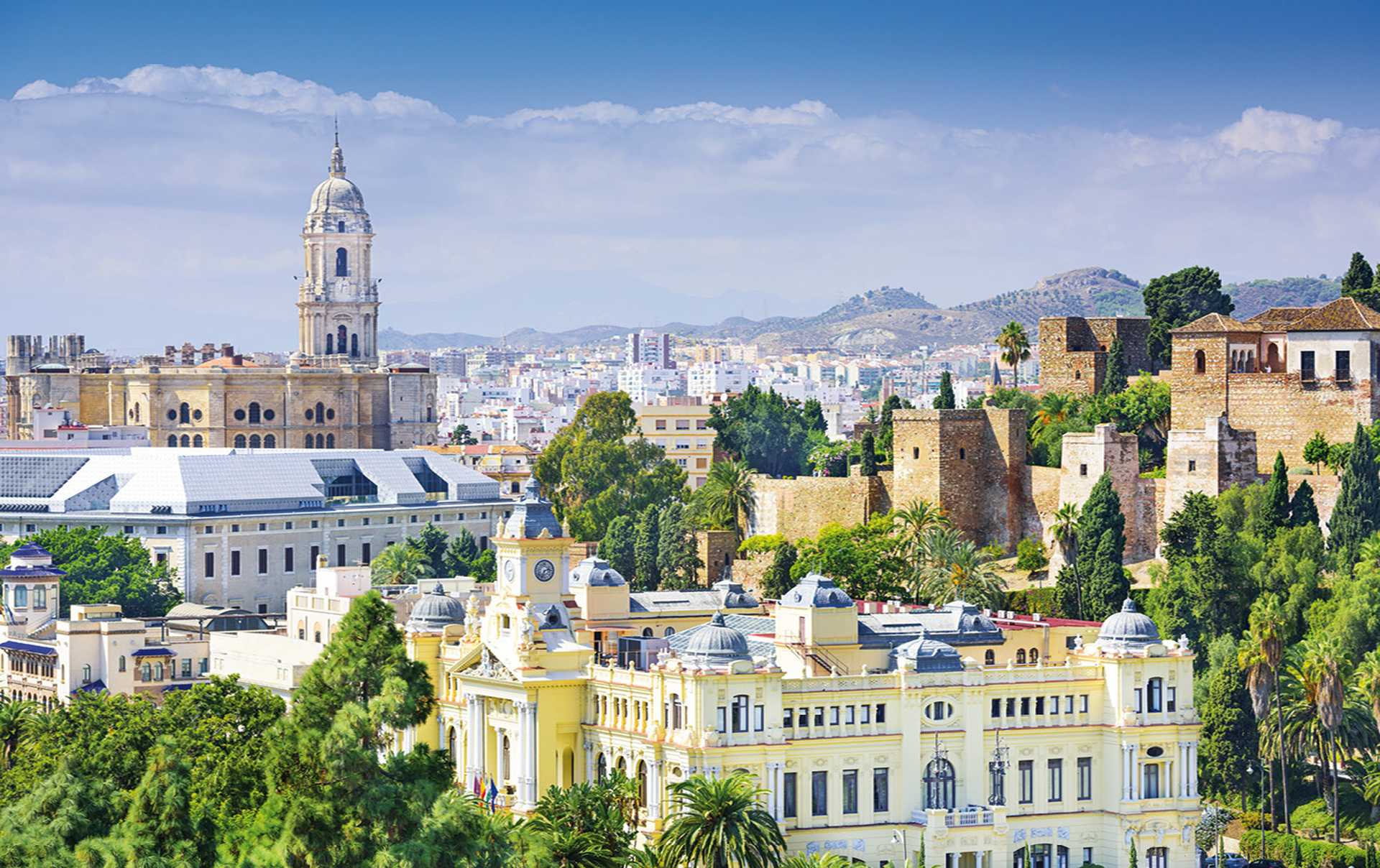 Beautiful Alhambra Palace complex in Spanish Granada on a sunny day captured on 16:9 photography. The amazing fortress and popular tourist spot is surrounded by green woods and mountains. 