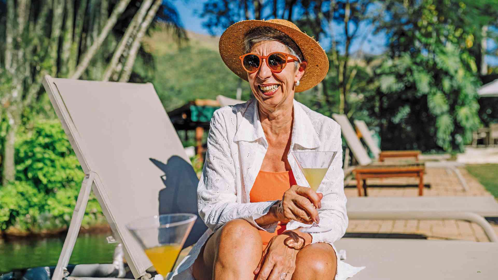 Woman with cocktail on sun lounger