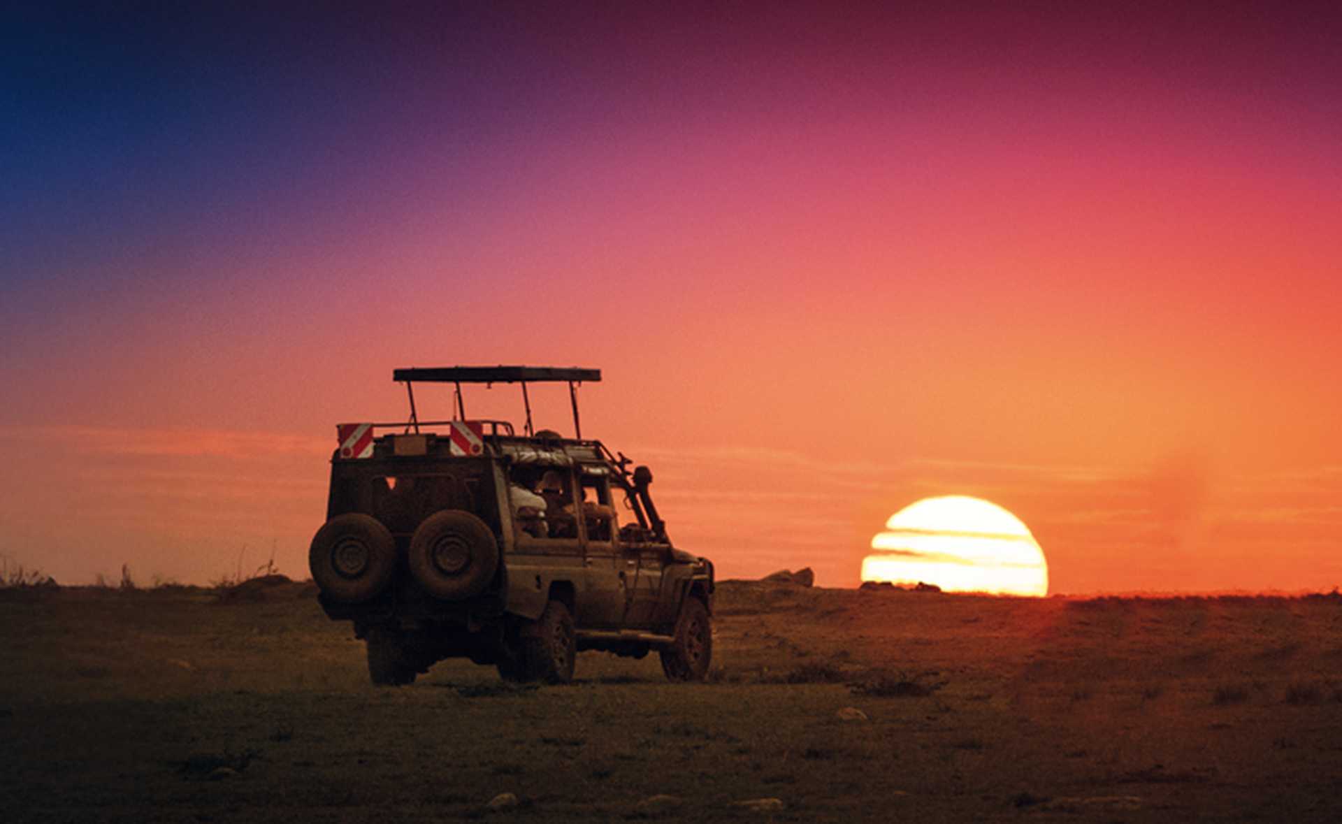 Safari vehicle at sunset