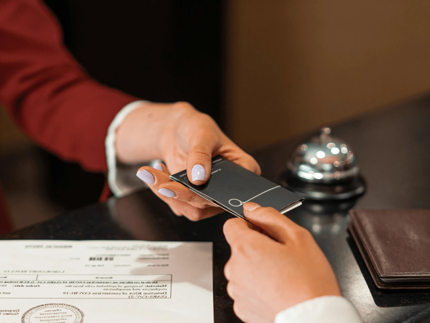 Hotel receptionist handing over a hotel keycard to a guest