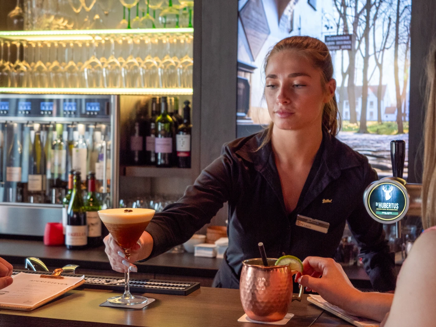 Bartender serving a drink at a bar