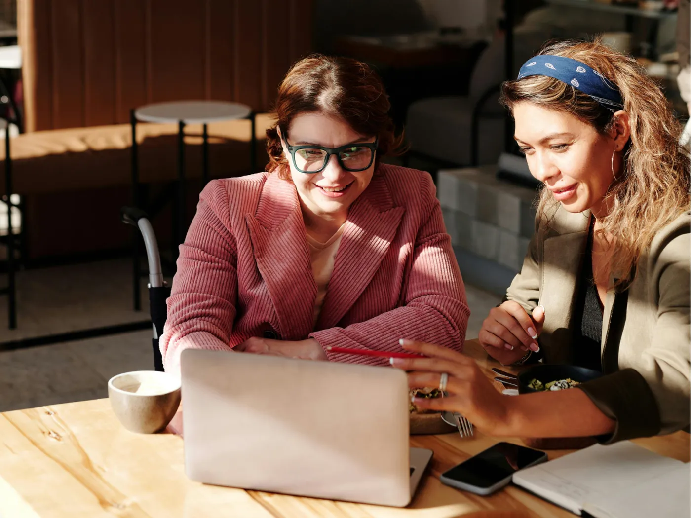Two hoteliers smiling at a laptop