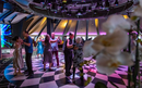 Couples dancing on the dance floor in a dimly lit, stylish room with colorful lighting.