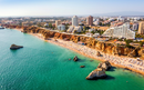 Aerial view of touristic Portimao with wide sandy Rocha beach, Algarve, Portugal