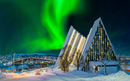 Stunning northern lights over the, snow-covered Eismeerkathedrale in Tromso, Norway