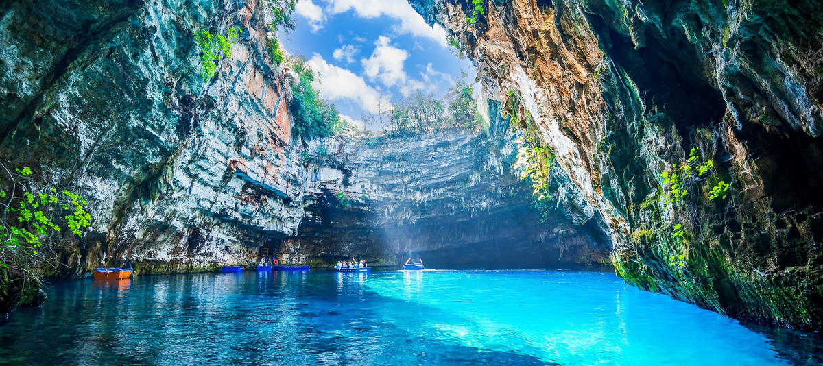 Melissani cave with a partially open roof, revealing clear skies, Kefalonia, Greece