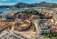 Aerial view of Cartagena port city in Spain surrounded by bastions and fortifications, medieval castle hill, roman amphitheater, bull ring