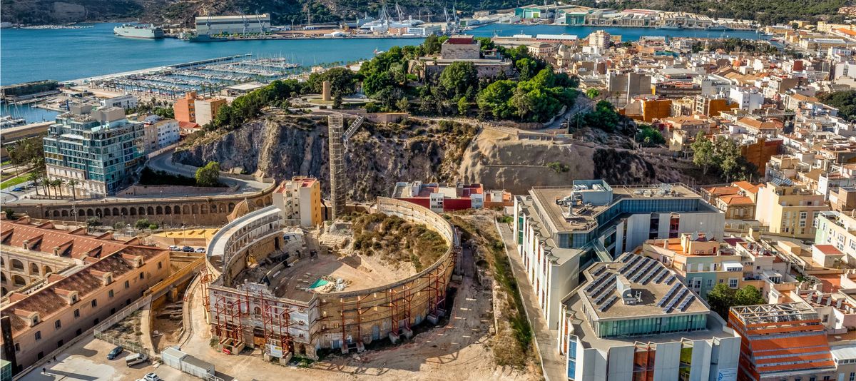 Aerial view of Cartagena port city in Spain surrounded by bastions and fortifications, medieval castle hill, roman amphitheater, bull ring