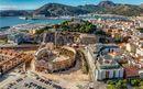 Aerial view of Cartagena port city in Spain surrounded by bastions and fortifications, medieval castle hill, roman amphitheater, bull ring