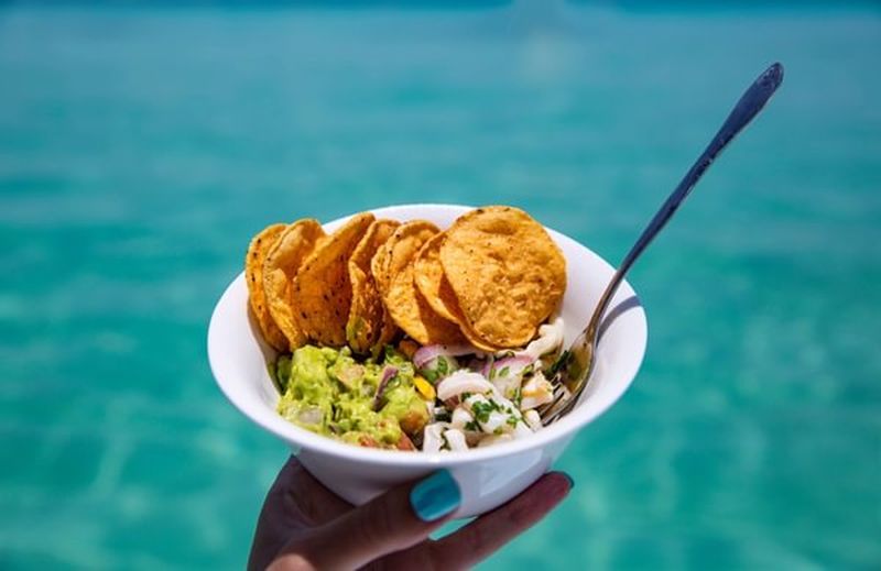 Woman Holding Fresh Ceviche Guacamole and Tortilla Chips Snack Bowl Made in Tropical Paradise