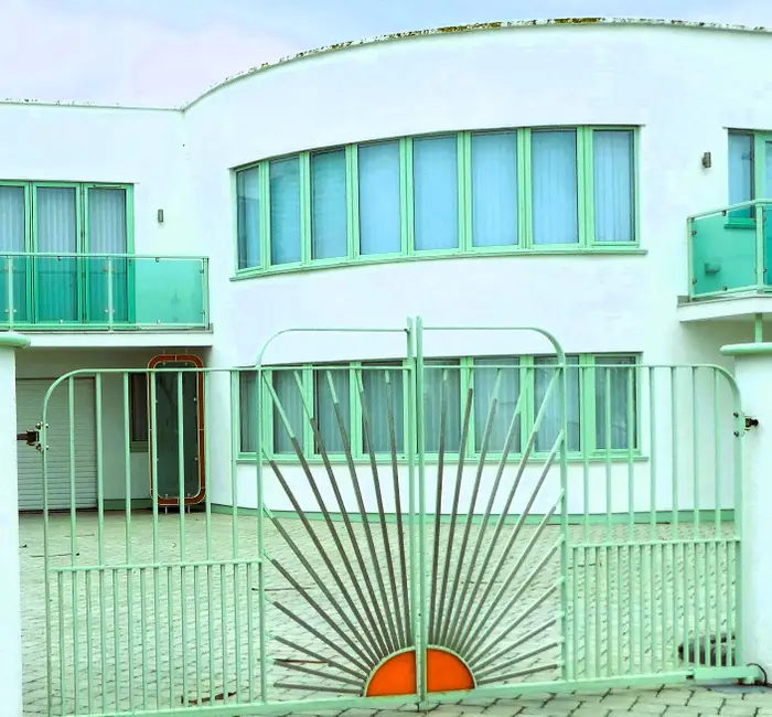 An art deco style house in Frinton-on-sea with a green and orange sunburst motif gate