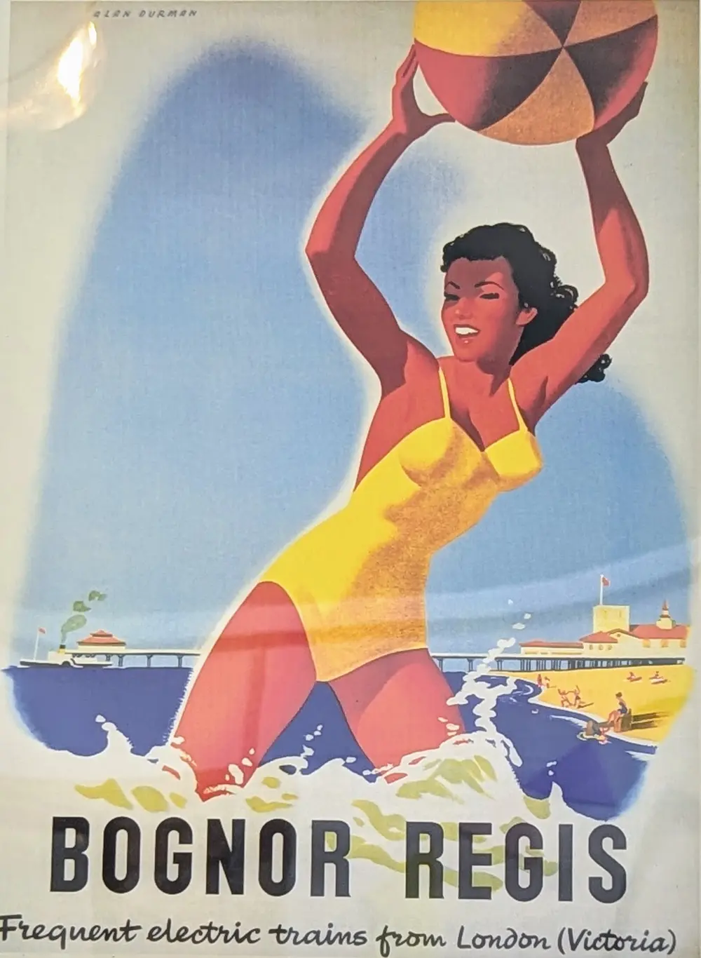 A vintage railway poster for Bognor Regis with the tagline 'Frequent electric trains from London (Victoria)' shows a woman in a yellow swimsuit in the sea, holding a beach ball above her head with the pier in the background.