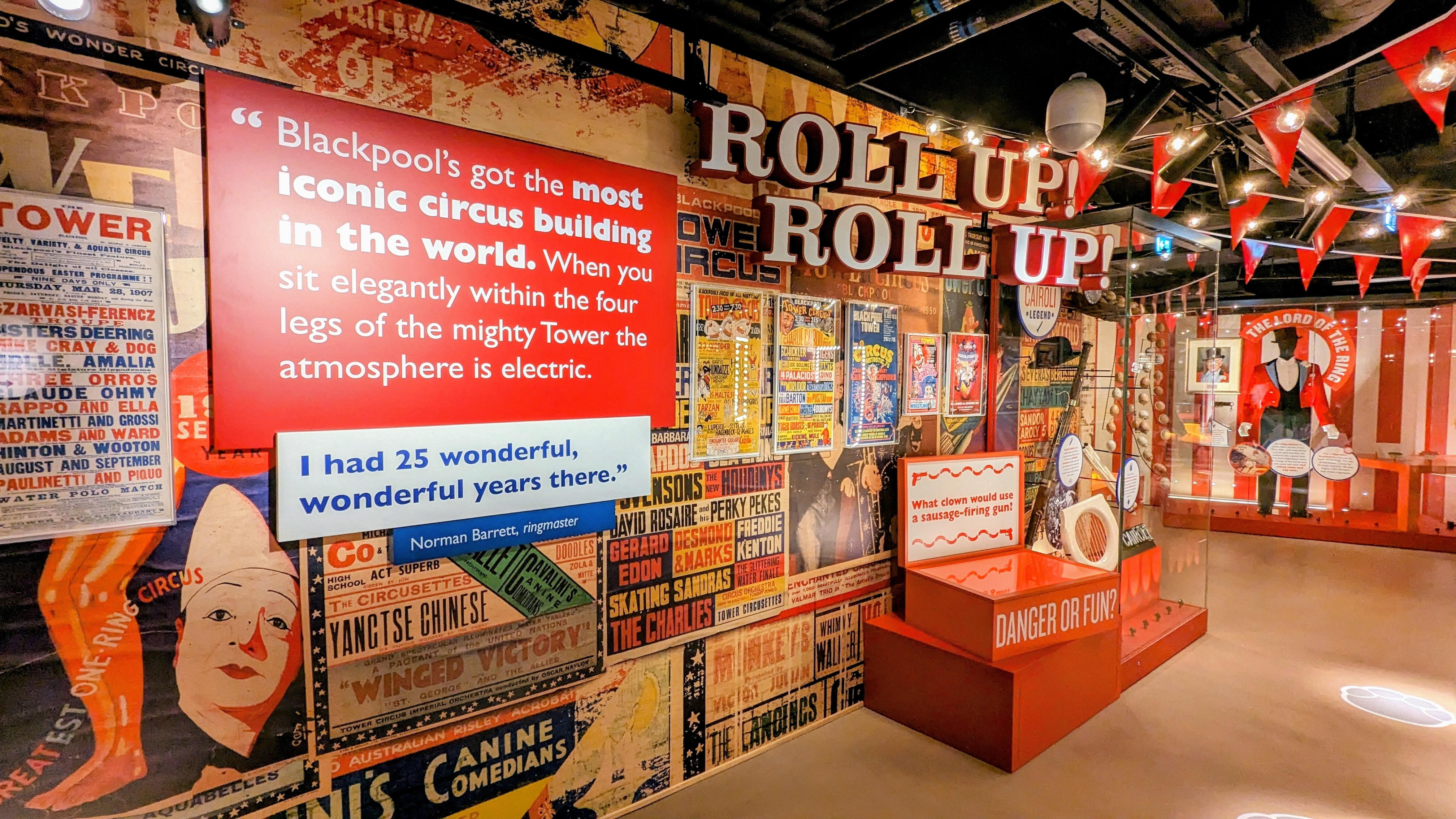 A vibrant circus-themed exhibition with colorful posters, quotes about Blackpool's iconic circus, red flags, and various historical displays.