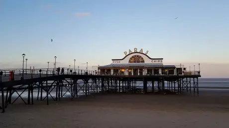 Cleethorpes Pier with Papa's Fish and Chips restaurant at dusk