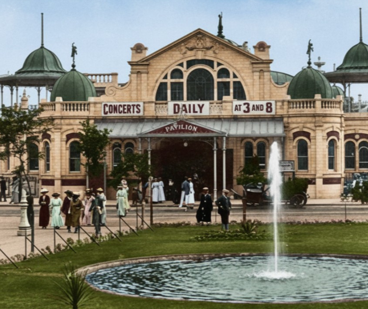 Historic pavilion hosting daily concerts at 3 and 8, with people in period attire walking nearby and a fountain in the foreground.