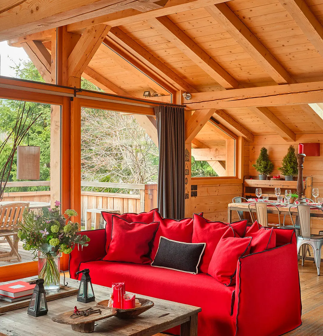 Location de Chalets Chamonix - Chalet Ardoise Les Rives d'Argentière - salon avec canapé rouge et baie vitrée sur la terrasse