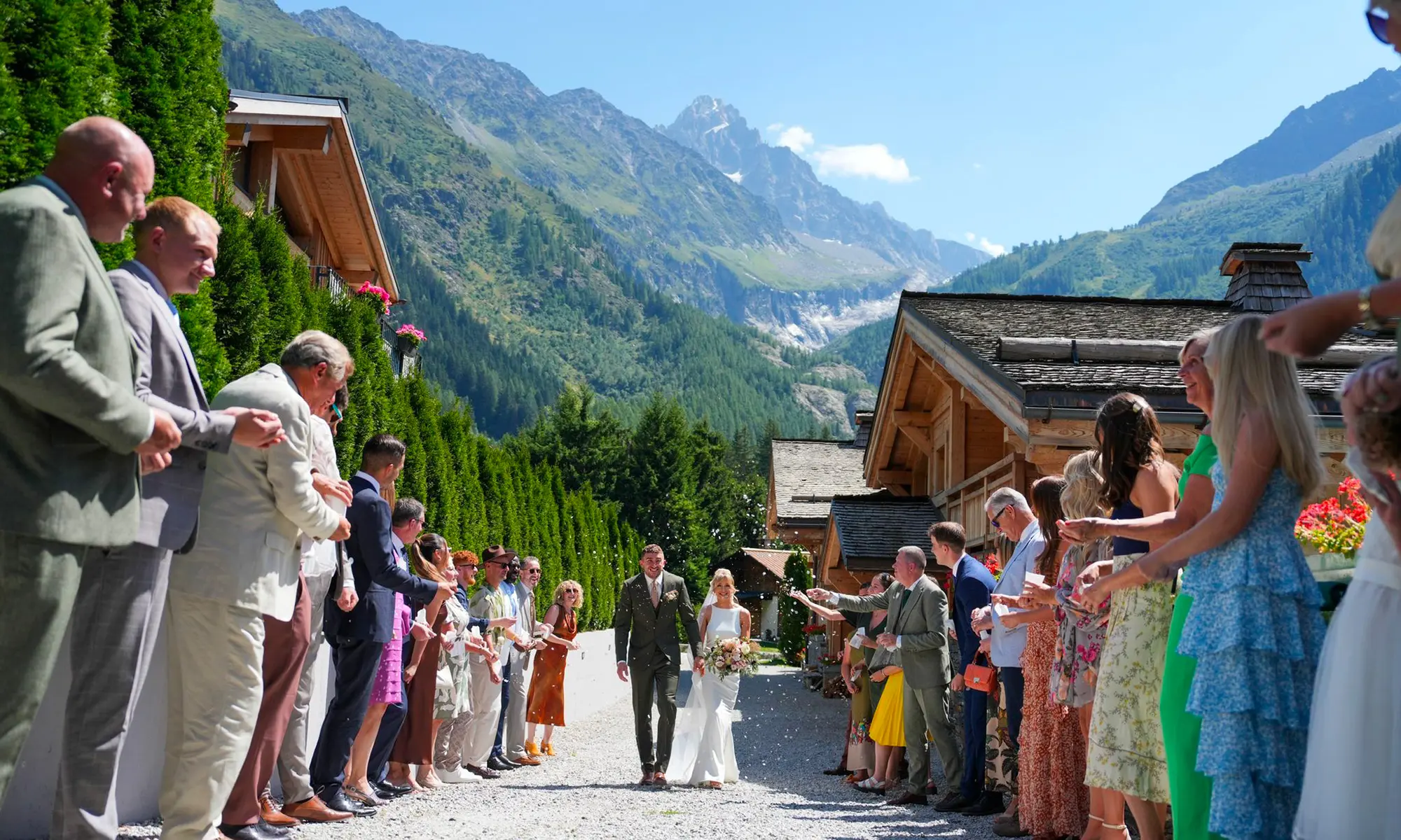 Location de Chalets Chamonix - mariage au hameau, les mariés accueillis par les invités devant les chalets