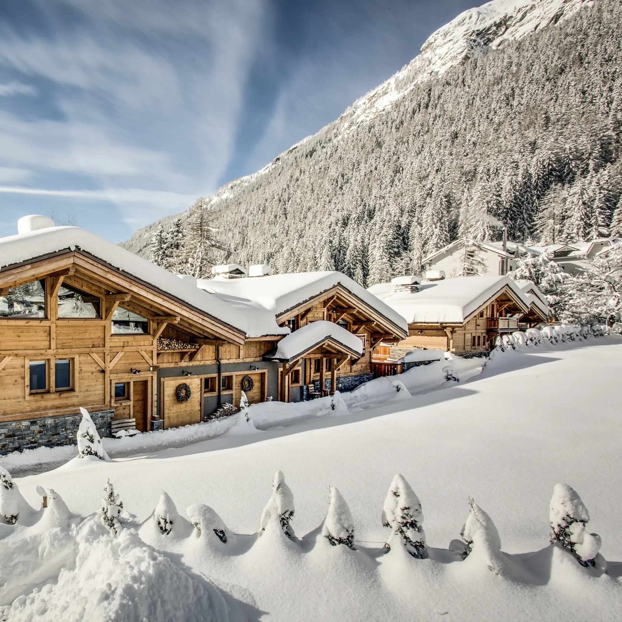 Location de Chalets Chamonix - les chalets enneigés au pied de la forêt et des sommets
