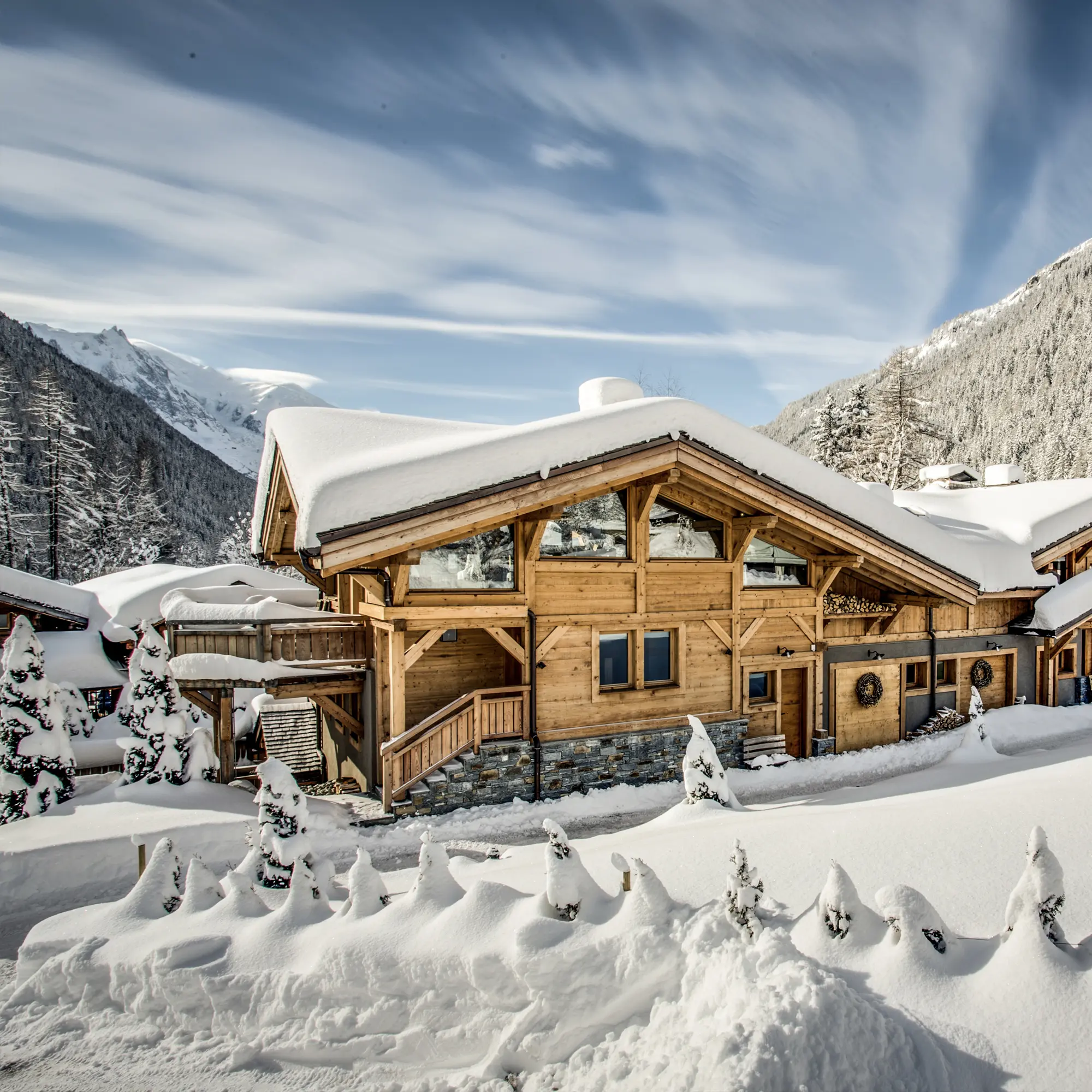Location de Chalets Chamonix - le hameau sous la neige, façades bois et sapins enneigés