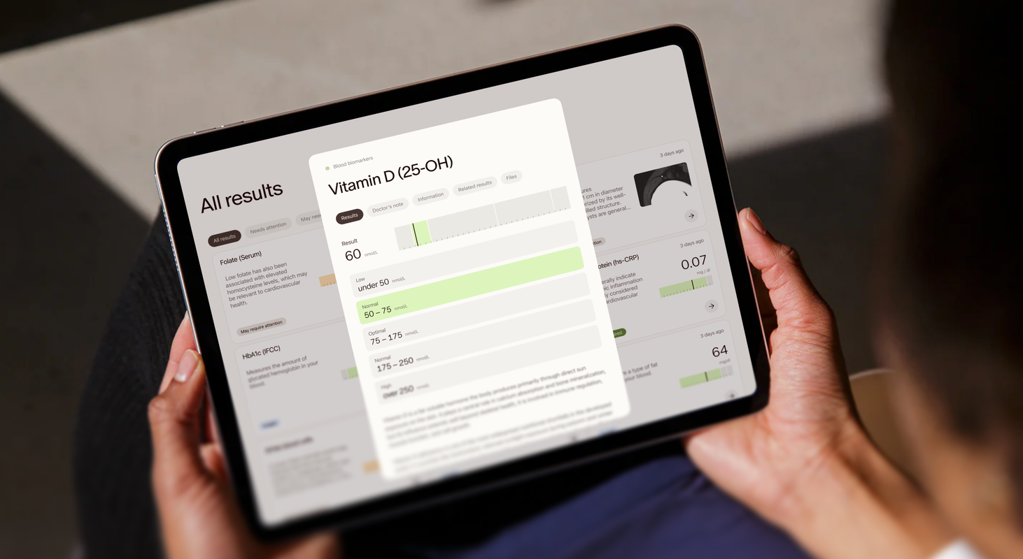 Person holding a tablet showing their Aeon blood results dashboard with a Vitamin D reading