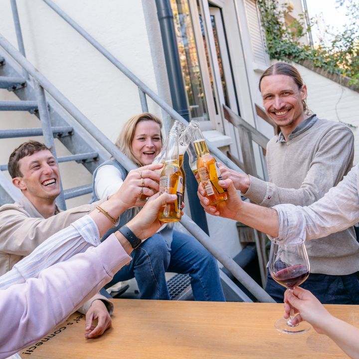 Collega's die buiten aan de picknicktafel het glas heffen