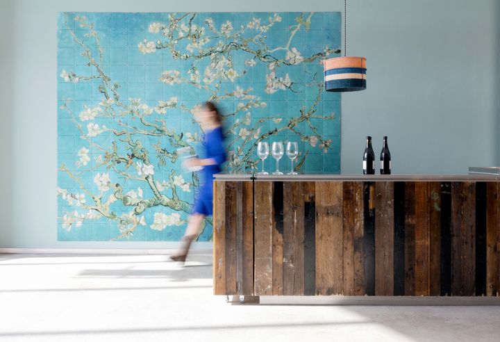 Wall-filling IXXI of Van Gogh’s Almond Blossom behind a bar, a woman walking past showing how large the surface is