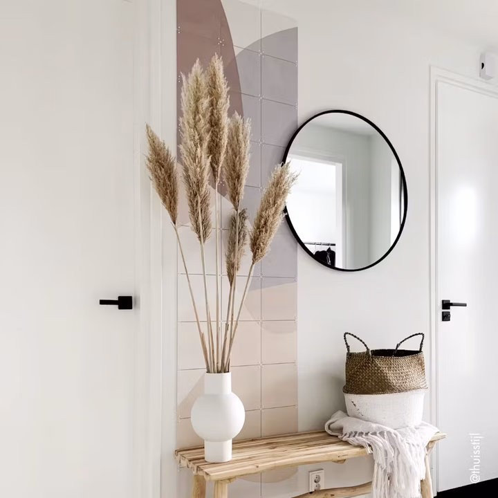 Pastel abstract design as a narrow portrait strip beside a door, next to a round mirror and a bench