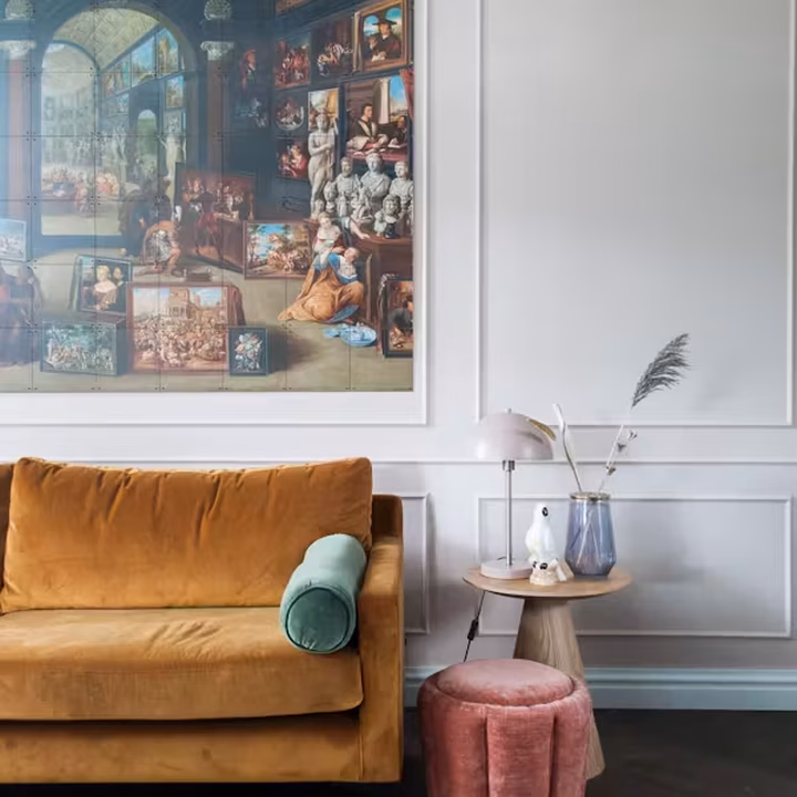 IXXI of a painted cabinet of curiosities crowded with paintings and sculptures, above an ochre sofa