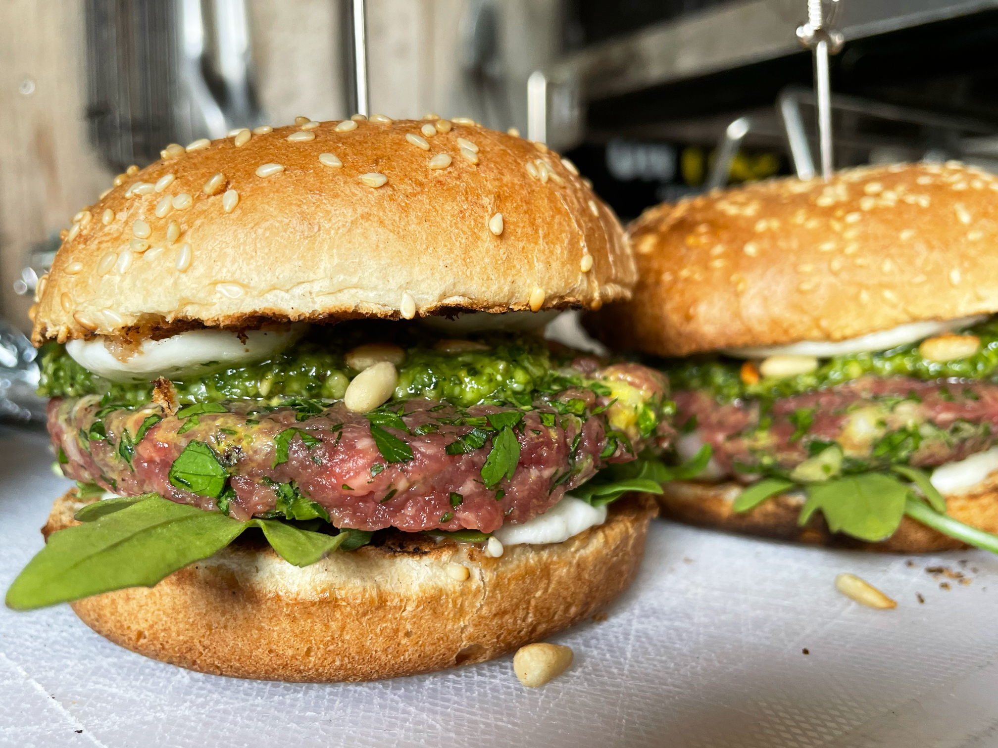 Raw burger met pesto, pijnboompitten, rucola en mozzarella