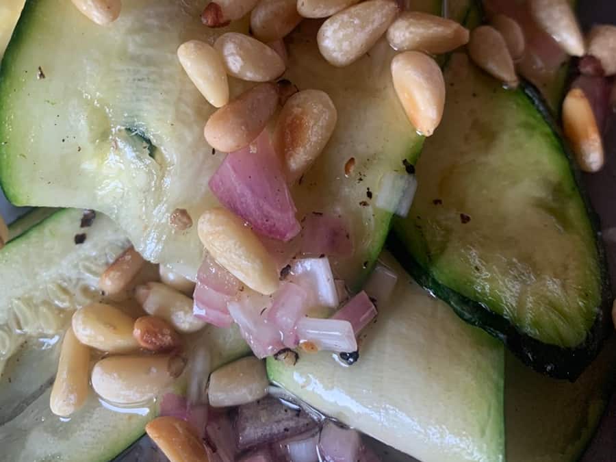 Gegrilde courgette met pijnboompitten van de barbecue