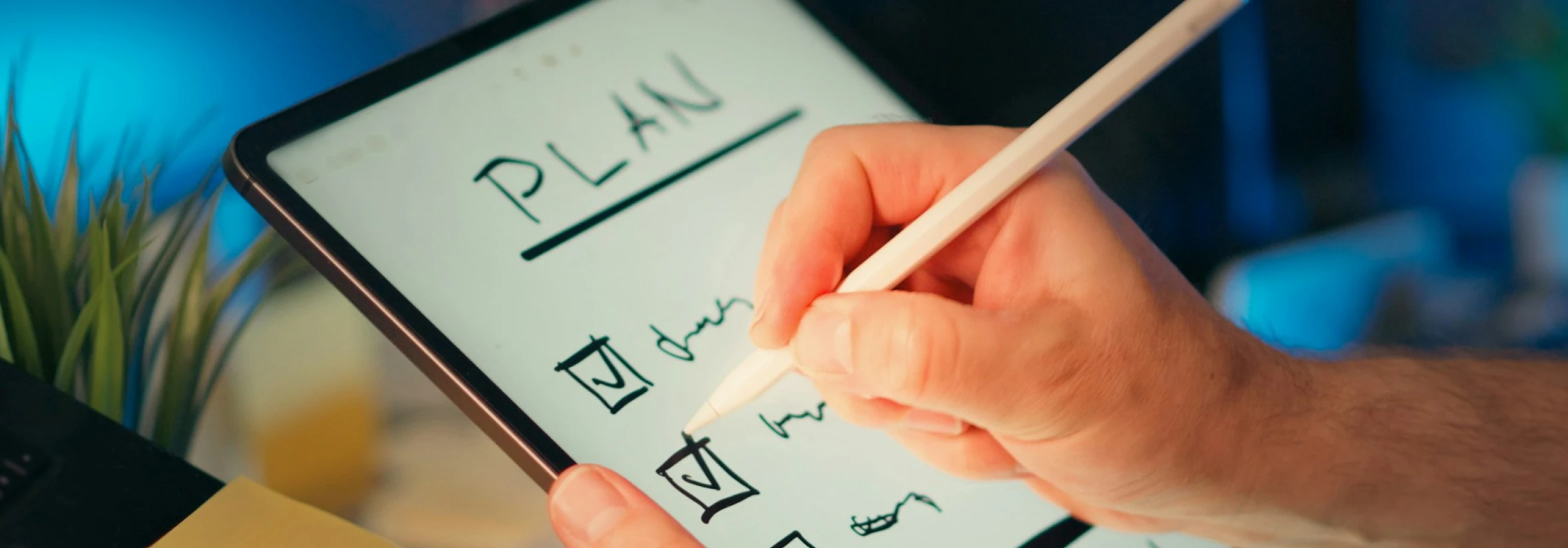 A person using an Apple Pencil with an iPad