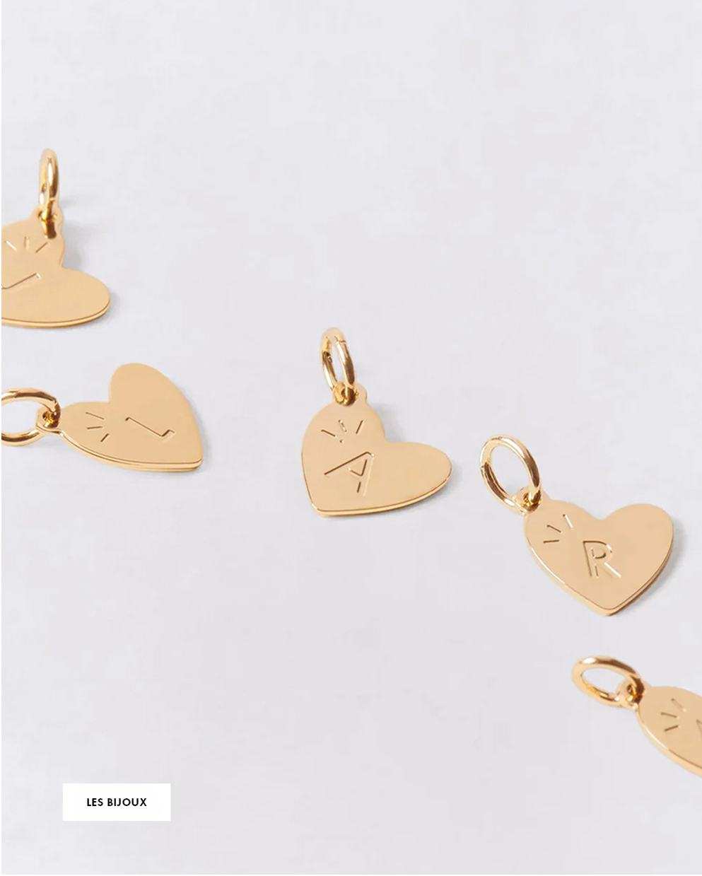 Gold heart-shaped charms with letters "L," "A," and "R" engraved, displayed on a white background.