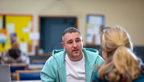 Man sitzt im Gespräch einer Frau gegenüber.