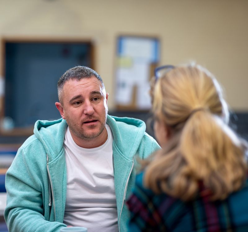 Man sitzt im Gespräch einer Frau gegenüber.