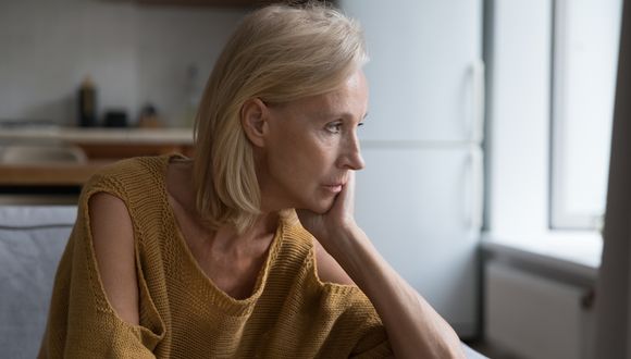 Frau sieht mit sorgenvollem Blick zur Seite.