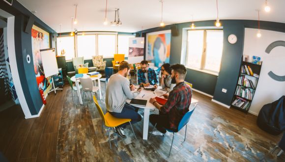 Junge Menschen sitzen zusammen im Meeting.