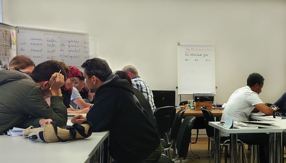 Eine Gruppe Flüchtlinge im Sprachkurs.