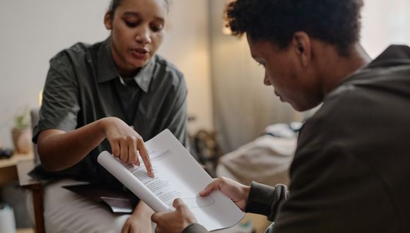 Sozialarbeiterin erklärt einem Jugendlichen ein Dokument