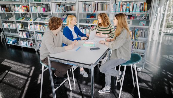 Gruppe bespricht am Tisch das Vorgehen im Workshop